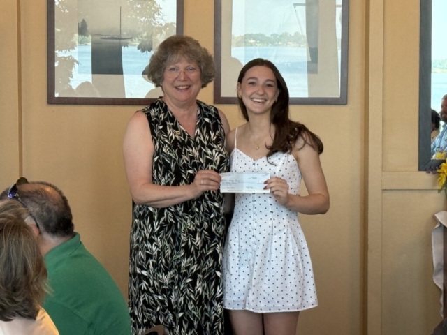 Megan receiving her $1,000 check